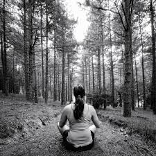 Mujer meditando en el bosque